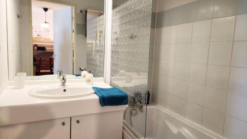 une salle de bain avec un lavabo et une douche avec un miroir dans l'établissement apartement 3 pieces avec piscine chauffée, à La Foux d'Allos