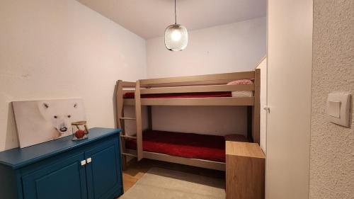 Cette petite chambre comprend des lits superposés et une armoire bleue. dans l'établissement apartement 3 pieces avec piscine chauffée, à La Foux d'Allos