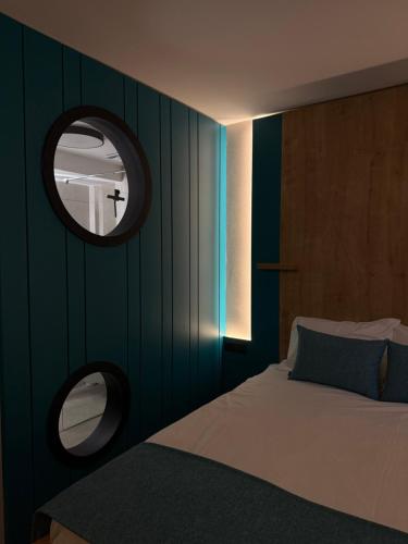 a bedroom with a bed and a round mirror at Hotel MANTOVA Vrhnika in Vrhnika
