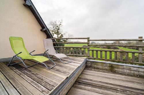 two green chairs sitting on a wooden deck at Gîte du Marais Deauville in Touques