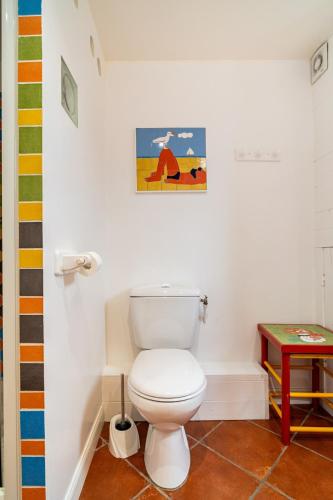 a bathroom with a toilet and a picture on the wall at Gîte du Marais Deauville in Touques