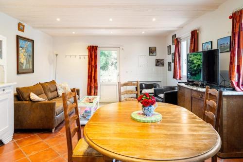a living room with a wooden table and a television at Gîte du Marais Deauville in Touques