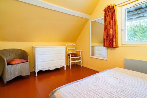 a bedroom with a bed and a dresser and a window at Gîte du Marais Deauville in Touques