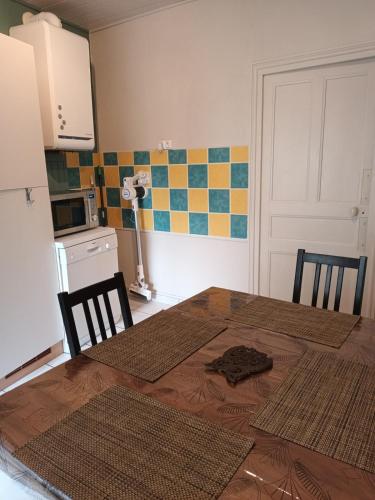 a kitchen with a table and two chairs and a kitchen with a kitchen at Maison aux pieds des volcans in Orcines