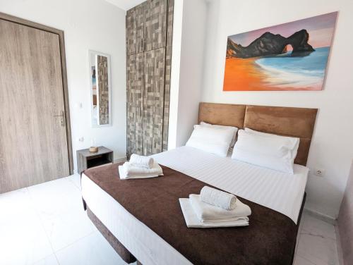 a bedroom with a large bed with towels on it at Villa Sonja in Neoi Epivates