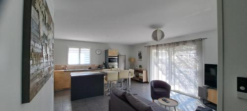une cuisine et un salon avec un canapé et une table dans l'établissement Maison 3 chambres, à Parentis-en-Born