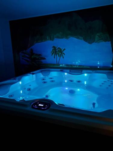 une baignoire jacuzzi dans une pièce sombre dans l'établissement So'Lovely maison entièrement privative avec jacuzzi à 10mn de Caen et 20mn des plages, à Vieux