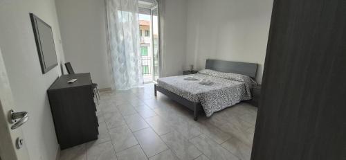 a bedroom with a bed and a table and a window at EremAre casa vacanza in Marina di Massa