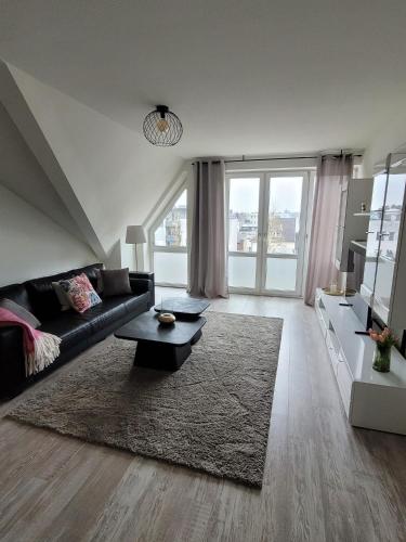 a living room with a black couch and a large window at Studio No 3 in Heinsberg