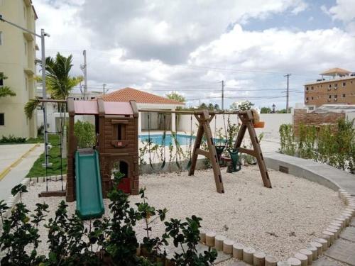 un parque infantil con columpio en un patio en Beautiful Accommodation in La Romana Beach View, en La Romana