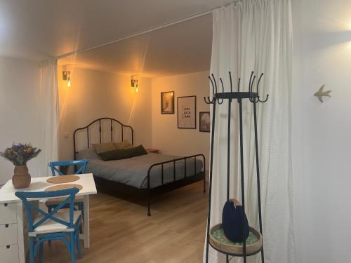 une chambre avec un lit, une table et des chaises dans l'établissement Charmant studio privatif proche Paris et Disneyland, à Thorigny-sur-Marne
