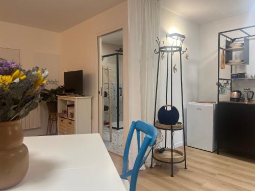 - un salon avec une table et une chaise bleue dans l'établissement Charmant studio privatif proche Paris et Disneyland, à Thorigny-sur-Marne