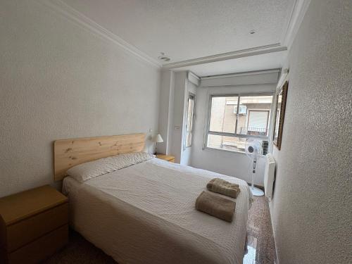 a small bedroom with a bed and a window at Major del Pla 25 in Elche