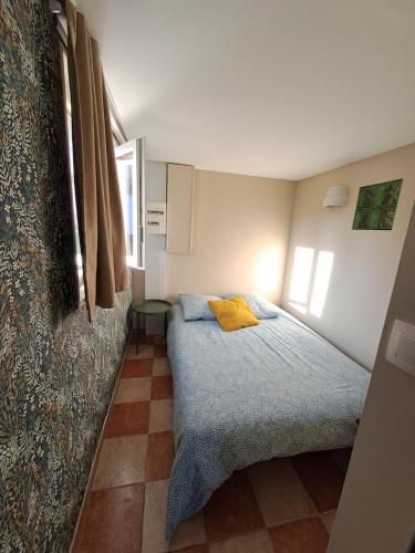 - une petite chambre avec un lit et une couverture bleue dans l'établissement Gîte des Près, à Verton
