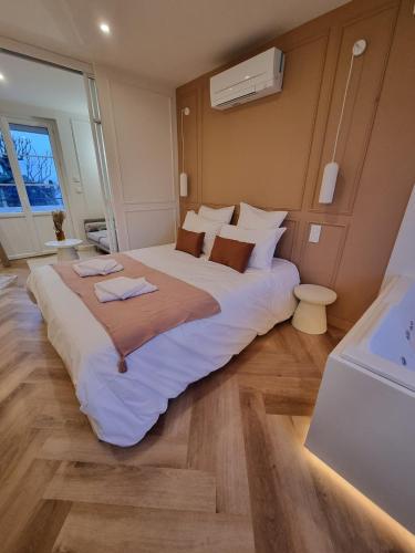ein Schlafzimmer mit einem großen weißen Bett mit zwei Handtüchern darauf in der Unterkunft Le Boudoir d'Elba - Balneotherapie & terrasse in Meyssac