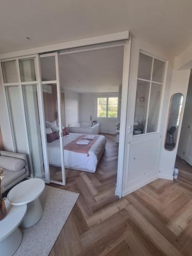 ein großes Schlafzimmer mit einem Bett und einem Badezimmer in der Unterkunft Le Boudoir d'Elba - Balneotherapie & terrasse in Meyssac