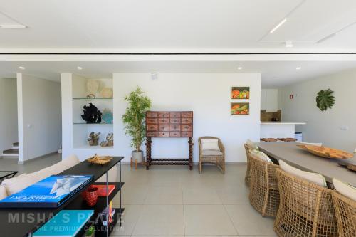 a living room with a long table and chairs at Modern 5BR Villa-Private Pool-Walk to Beach & Oura-10 Guests by Misha's Place in Albufeira