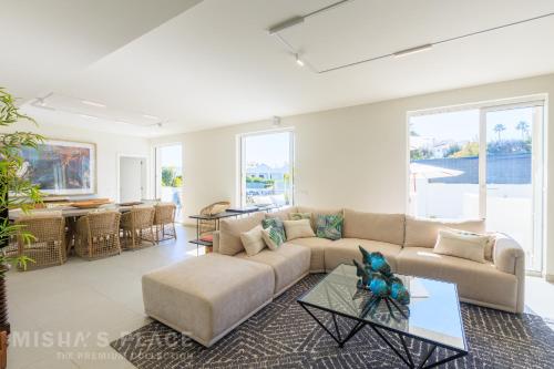a living room with a couch and a table at Modern 5BR Villa-Private Pool-Walk to Beach & Oura-10 Guests by Misha's Place in Albufeira