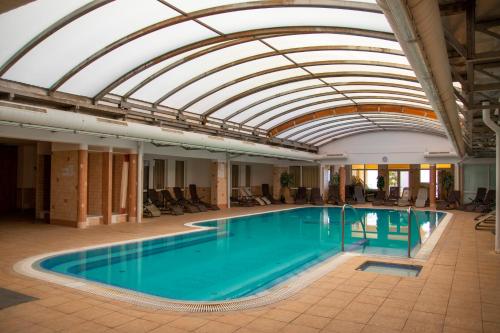 a pool in a building with a glass ceiling at Thermal Residence Apartman in Zalakaros