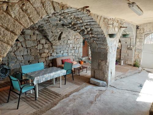 d'une terrasse avec une table et des chaises dans un mur en pierre. dans l'établissement Le nid d'hirondelles, à Labeaume