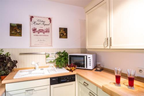 une cuisine avec un évier et un micro-ondes dans l'établissement Le Daguerre, à Paris