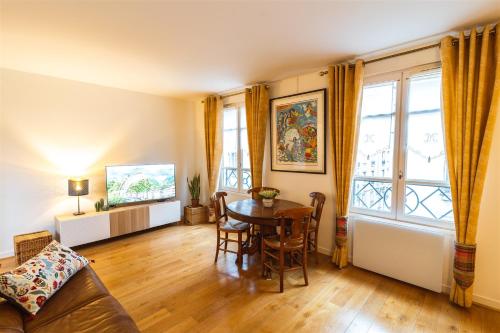 un salon avec une table et un canapé dans l'établissement Le Daguerre, à Paris