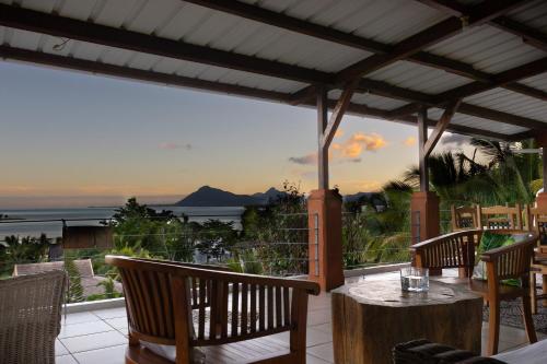 a patio with a table and chairs and a view of the ocean at Residence Ma Vie Là Ltee in Le Morne