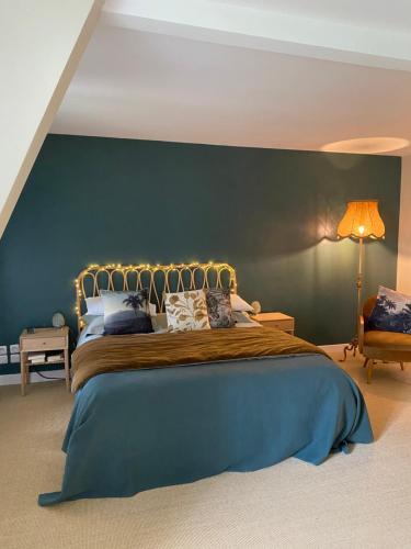 une chambre avec un grand lit avec un mur végétal dans l'établissement 2 Chambres, spéciales 24H DU MANS, au Mans