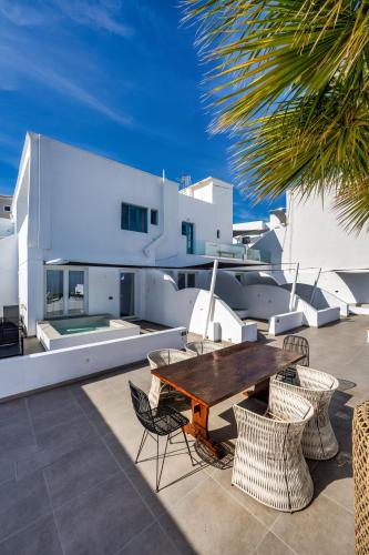 a patio with a wooden table and chairs at Callia Retreat Suites - Adults Only in Fira