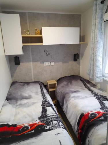 une chambre avec deux lits avec une petite voiture dessus dans l'établissement Camping, aux Mathes