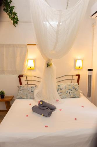 a bed with a curtain and a hat on it at Residence Ma Vie Là Ltee in Le Morne