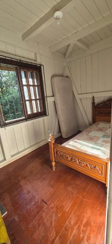 a bedroom with a bed in a room with two windows at Sítio Vale Das Araucarias in Não Me Toques