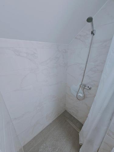 a bathroom with a shower with white marble walls at Stara škola in Granice