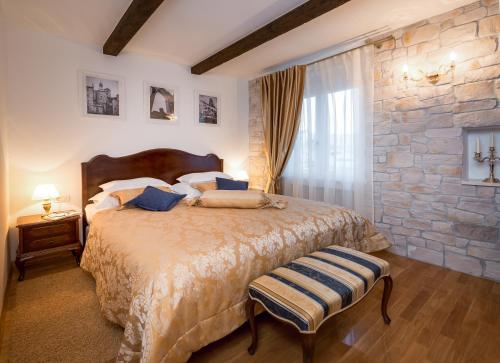 a bedroom with a large bed and a stone wall at Opera Heritage Rooms in Split
