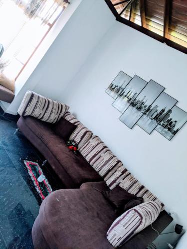 a living room with a brown couch and a window at The tower in Panakaduwa