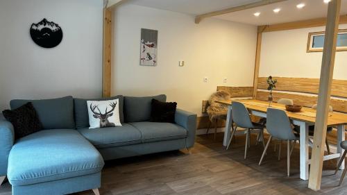 un salon avec un canapé bleu et une table dans l'établissement Logement T4 Tout confort - 6 Pers, à Luz-Saint-Sauveur