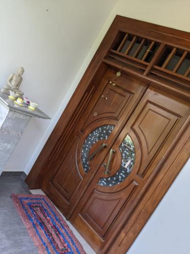 a wooden door with a round window on it at The tower in Panakaduwa