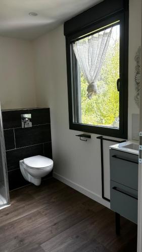 une salle de bain avec toilettes et fenêtre dans l'établissement Logement T4 Tout confort - 6 Pers, à Luz-Saint-Sauveur