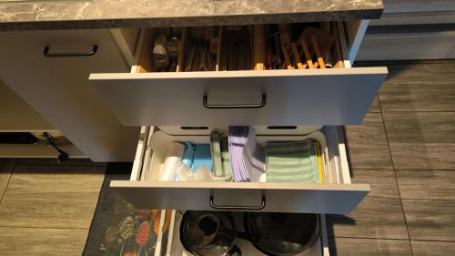 an open drawer in a kitchen with a washing machine at Pirtelė Rykštelė in Karmėlava