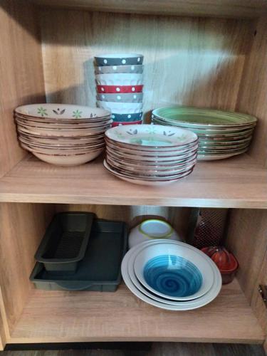 a wooden shelf with plates and dishes on it at Solimmo in Temù