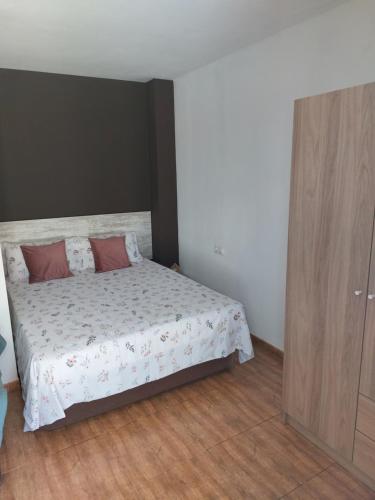 a bedroom with a bed and a wooden cabinet at Casa BLAVA in Benicarló