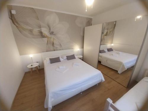 a small bedroom with two beds and a mirror at Dome&Mare in Slatine