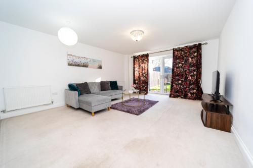 a living room with a couch and a tv at Specious modern 3-bed house near city centre in Reading