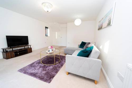 a living room with a couch and a tv at Specious modern 3-bed house near city centre in Reading