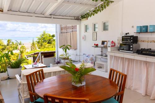 a kitchen and dining room with a table and chairs at Residence Ma Vie Là Ltee in Le Morne