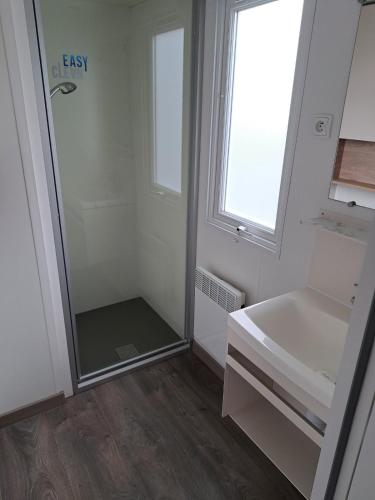 une salle de bain avec une douche, un lavabo et un miroir dans l'établissement Mobil-home 4-6 pers - Terrasse & Linge - Domaine de Kerlann, à Pont-Aven