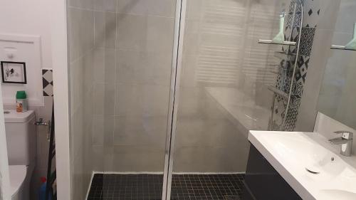 une salle de bain blanche avec une douche et un lavabo dans l'établissement La Balancelle, à Marseille