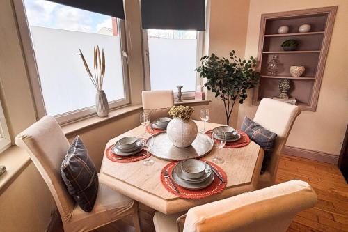a dining room with a table and chairs and a window at Glasgow City - Large Stylish 2 Bed Flat in Unique Ibrox Location Walking Distance to Subway and Free On-Street Parking in Glasgow