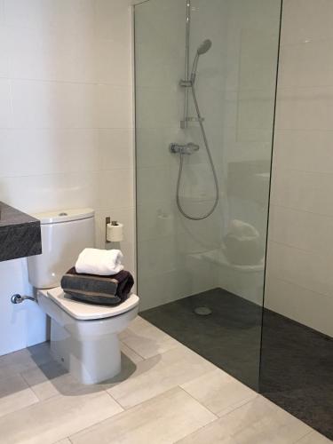 a bathroom with a toilet and a glass shower at Apartaments El Cine in Roses