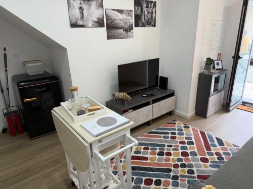 a living room with a table and a tv at Francisca River House in Vila Nova de Gaia